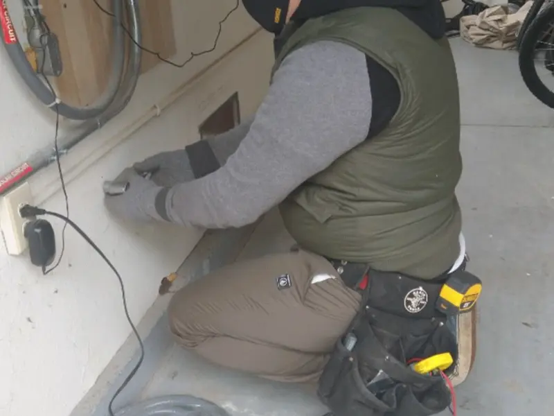 Electrician performing outlet wiring in a Superior garage